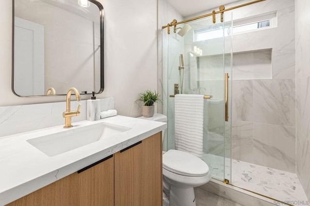 bathroom featuring vanity, an enclosed shower, and toilet