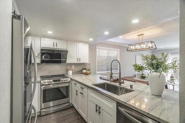 kitchen with stainless steel appliances, light stone countertops, sink, and white cabinets