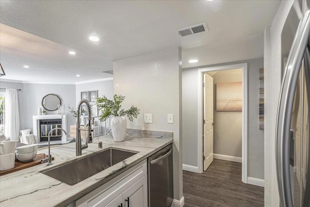 kitchen with dark wood-type flooring, sink, light stone counters, white cabinetry, and stainless steel appliances