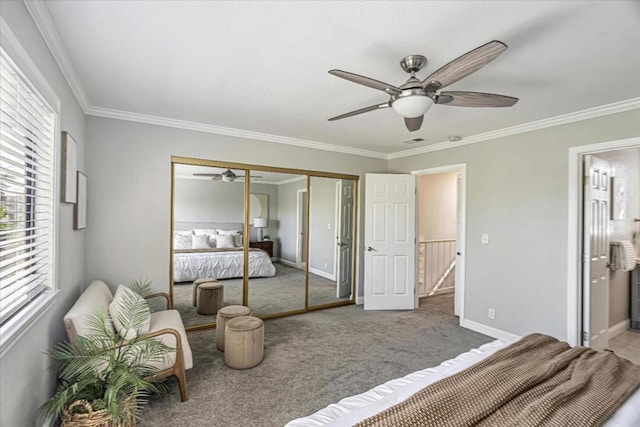 carpeted bedroom with ornamental molding, ensuite bathroom, and a closet