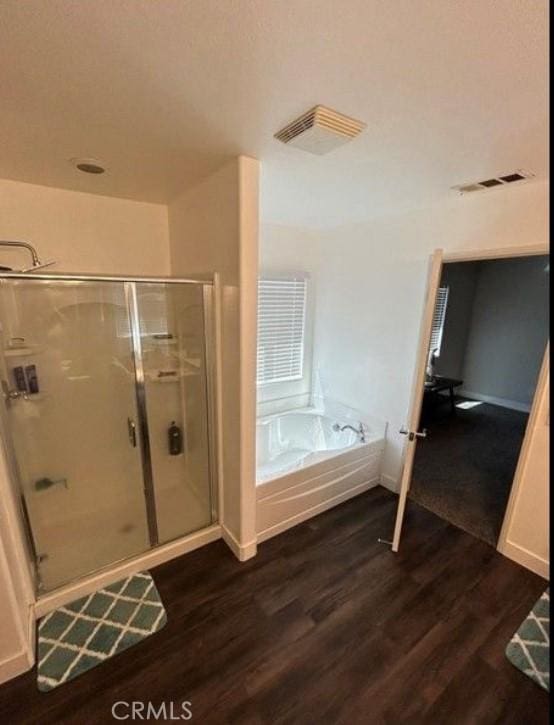 bathroom featuring shower with separate bathtub and hardwood / wood-style floors