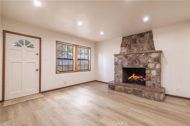 unfurnished living room with a fireplace and light hardwood / wood-style floors