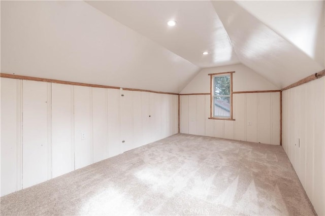 bonus room featuring lofted ceiling and light carpet