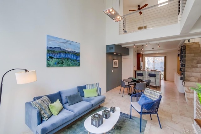 living room with a towering ceiling and ceiling fan