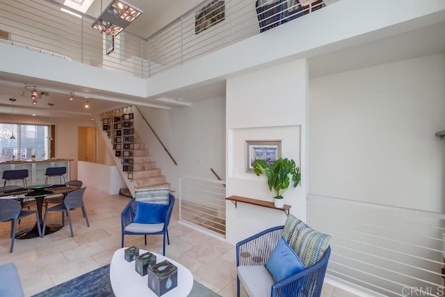 interior space featuring a skylight, light tile patterned flooring, and a high ceiling