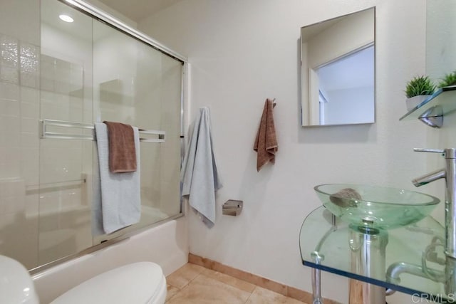 full bathroom featuring tile patterned flooring, sink, shower / bath combination with glass door, and toilet