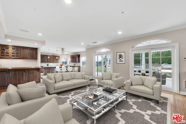 living room featuring crown molding and light wood-type flooring