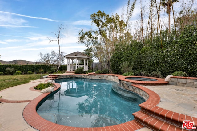 view of pool featuring a mountain view, a gazebo, a patio area, and an in ground hot tub