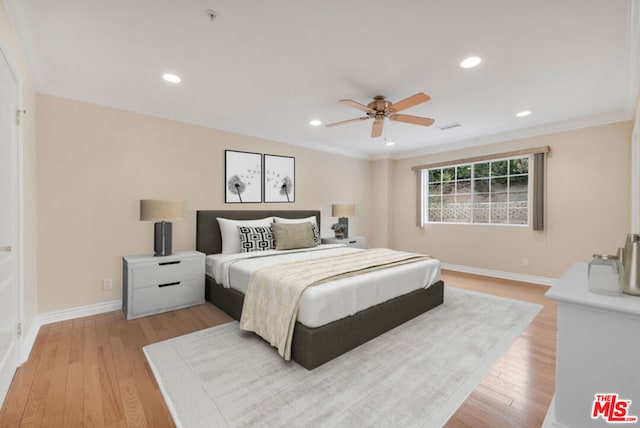 bedroom featuring crown molding, light hardwood / wood-style flooring, and ceiling fan