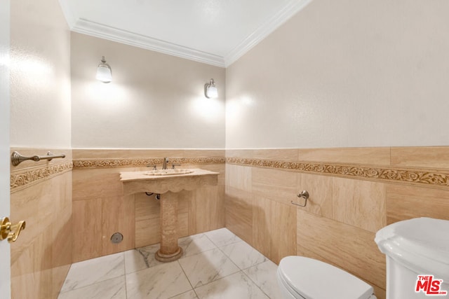 bathroom with tile walls, sink, ornamental molding, and toilet