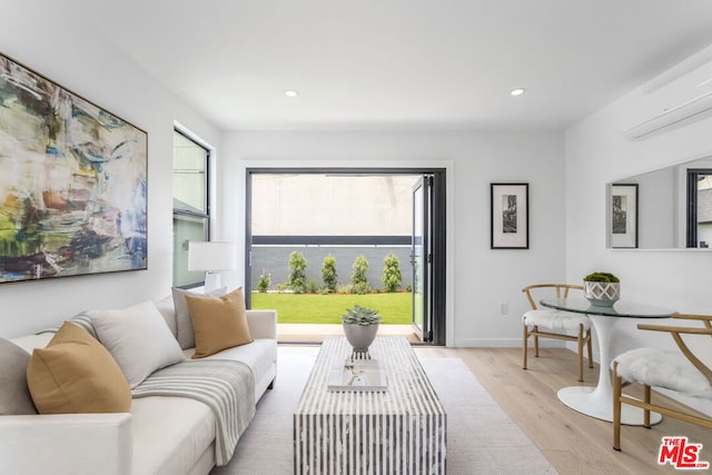 living room featuring an AC wall unit and light wood-type flooring