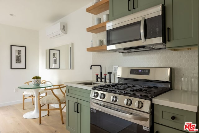 kitchen featuring stainless steel appliances, a wall mounted air conditioner, and green cabinets