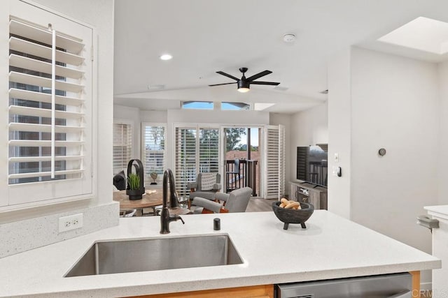 kitchen featuring ceiling fan, lofted ceiling, dishwasher, and sink