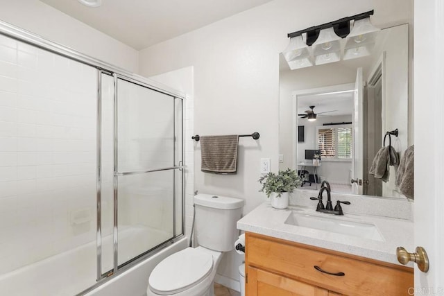 full bathroom featuring enclosed tub / shower combo, vanity, and toilet