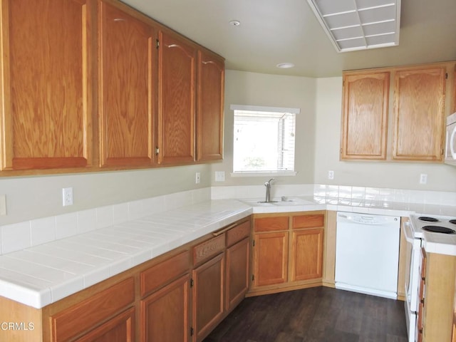 kitchen featuring sink, dark hardwood / wood-style flooring, tile counters, kitchen peninsula, and white appliances