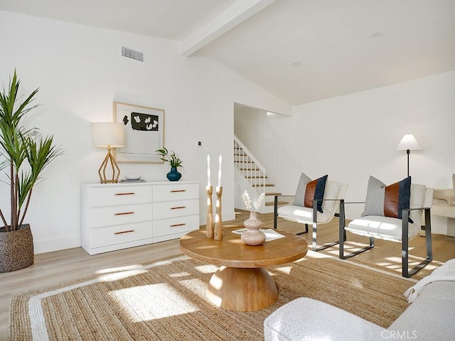 living area featuring light hardwood / wood-style floors and vaulted ceiling with beams