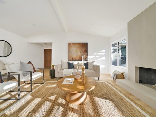 living room featuring light hardwood / wood-style floors and vaulted ceiling with beams