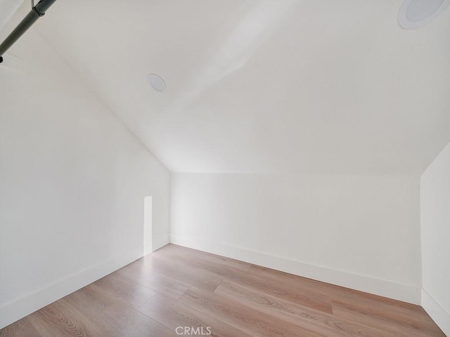 bonus room with lofted ceiling and light wood-type flooring