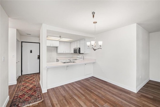 kitchen featuring sink, range, dark hardwood / wood-style flooring, kitchen peninsula, and white cabinets