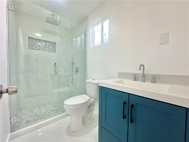 bathroom with vanity, toilet, and a shower with shower door