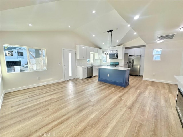 kitchen featuring pendant lighting, sink, appliances with stainless steel finishes, white cabinetry, and blue cabinets