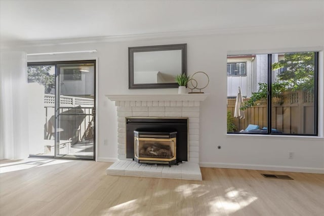 unfurnished living room with crown molding, plenty of natural light, and light wood-type flooring