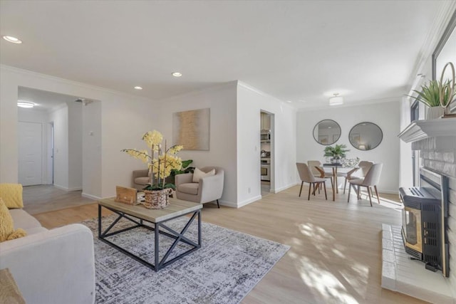 living room with ornamental molding, heating unit, and light wood-type flooring