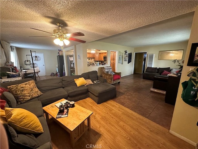 living room with hardwood / wood-style floors, a textured ceiling, and ceiling fan