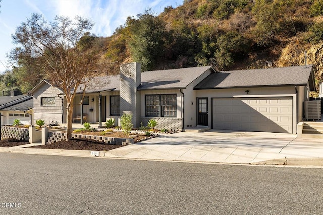 single story home featuring central AC and a garage