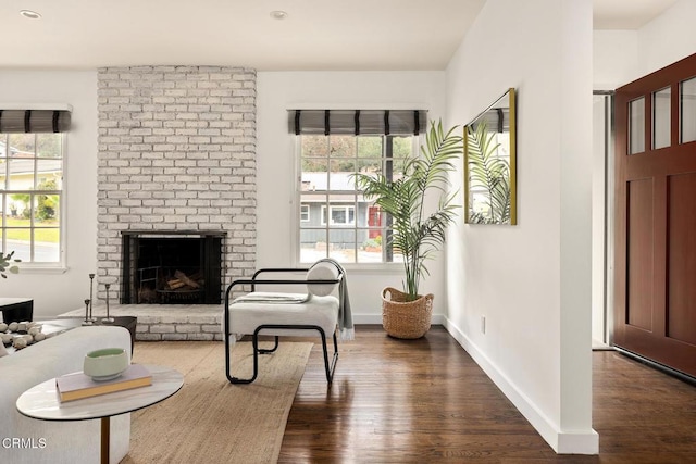 sitting room with plenty of natural light, dark wood-type flooring, and a fireplace