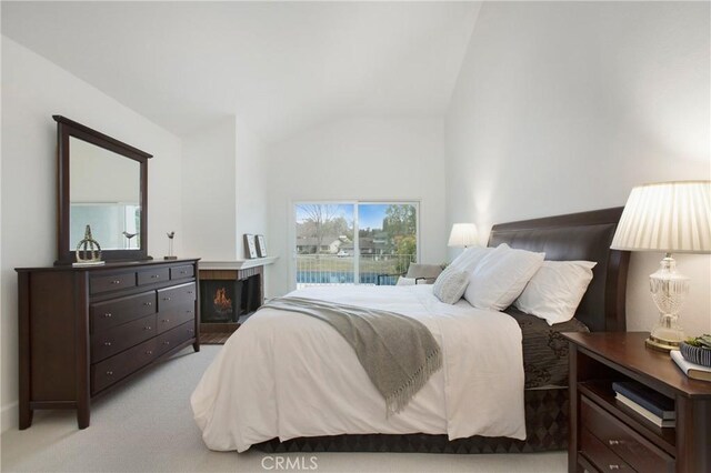 carpeted bedroom featuring lofted ceiling and access to outside