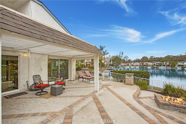 view of patio featuring a fire pit, a pergola, and a water view