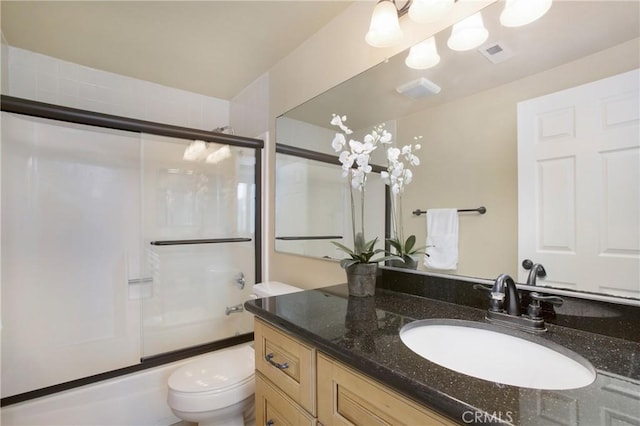 full bathroom with vanity, shower / bath combination with glass door, and toilet