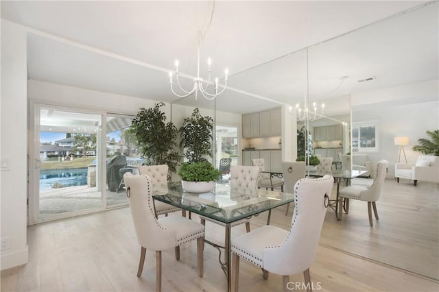 dining room with a chandelier and light hardwood / wood-style flooring