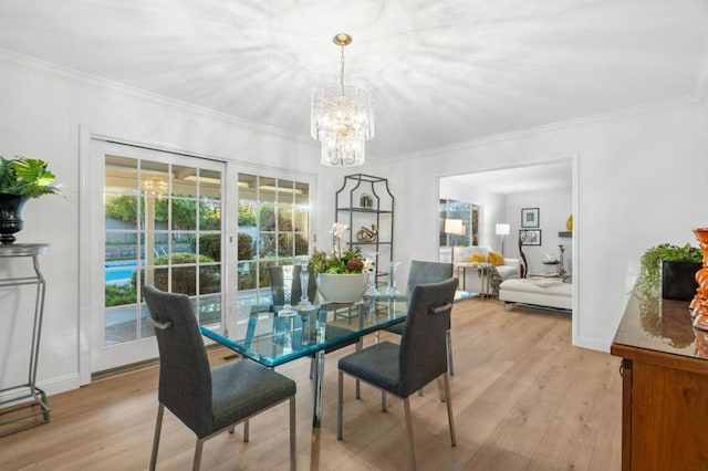 dining area with an inviting chandelier, crown molding, and light hardwood / wood-style floors