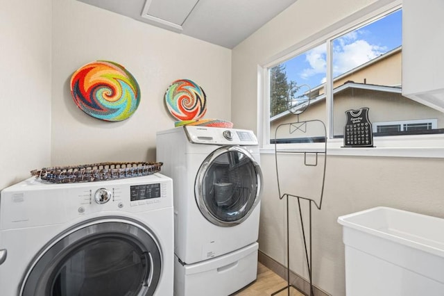 laundry room featuring light hardwood / wood-style flooring and washer and clothes dryer