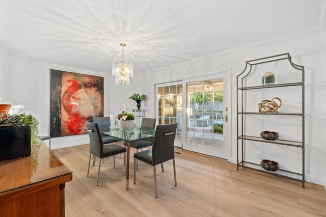 dining area featuring an inviting chandelier, light hardwood / wood-style flooring, and ornamental molding