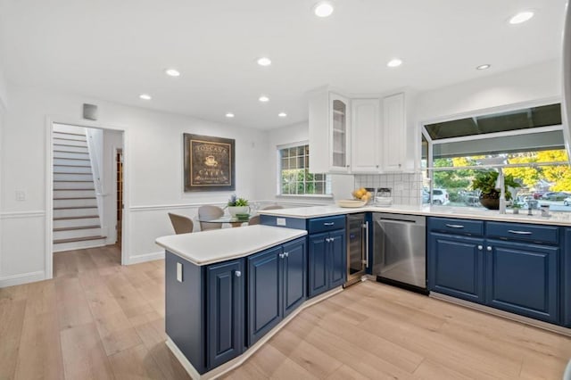 kitchen with white cabinetry, dishwasher, blue cabinetry, and kitchen peninsula