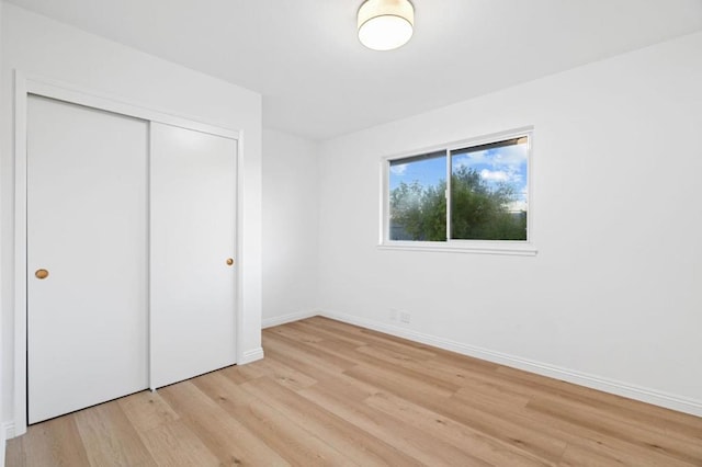 unfurnished bedroom featuring light hardwood / wood-style floors and a closet