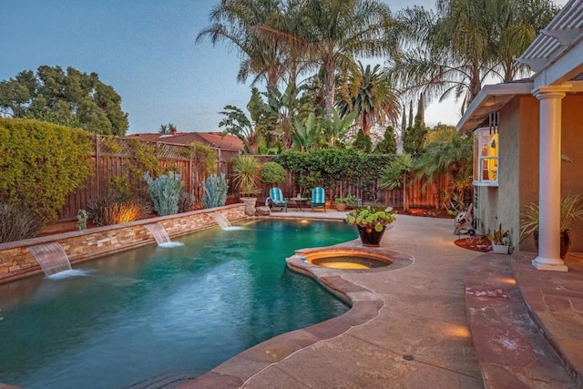 view of pool with an in ground hot tub, pool water feature, and a patio area