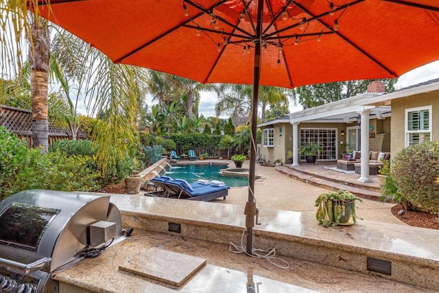 view of pool featuring exterior kitchen, grilling area, and a patio area