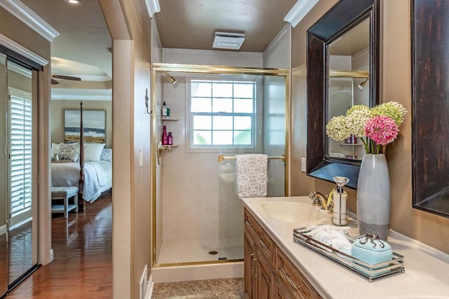 bathroom featuring crown molding, vanity, a shower with door, and hardwood / wood-style floors