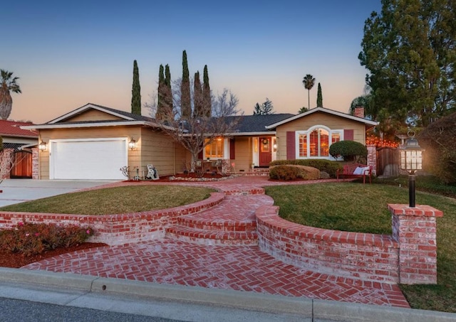 ranch-style house featuring a yard and a garage