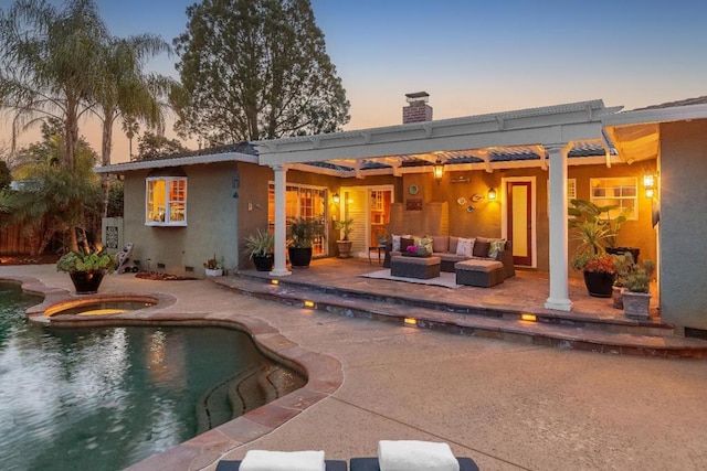 back house at dusk featuring a pool with hot tub, a pergola, a patio area, and outdoor lounge area