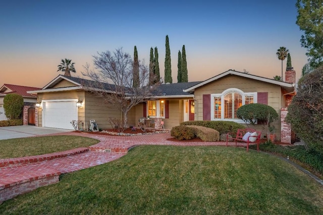 single story home featuring a garage and a lawn