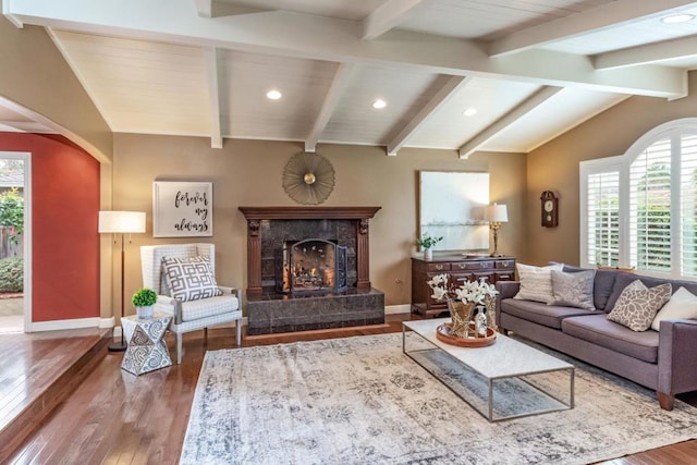 living room featuring vaulted ceiling with beams, hardwood / wood-style floors, and a high end fireplace