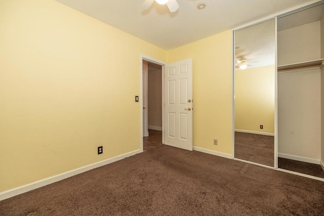 unfurnished bedroom with ceiling fan, dark carpet, and a closet