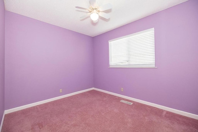 unfurnished room with ceiling fan and carpet flooring