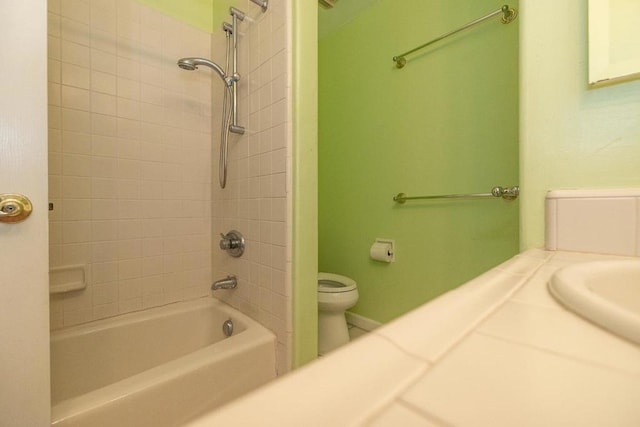 bathroom with tiled shower / bath and toilet