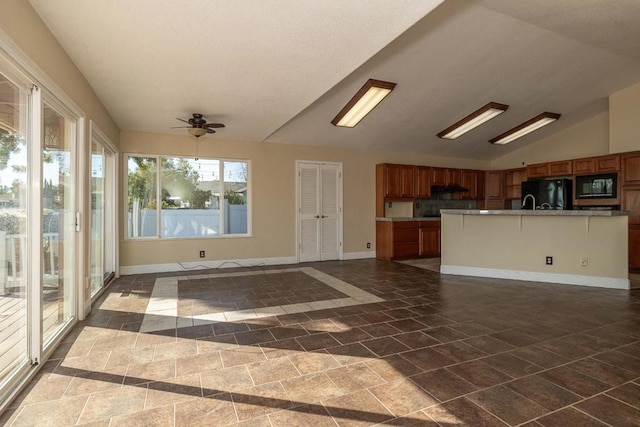 kitchen featuring extractor fan, vaulted ceiling, a center island with sink, ceiling fan, and black appliances